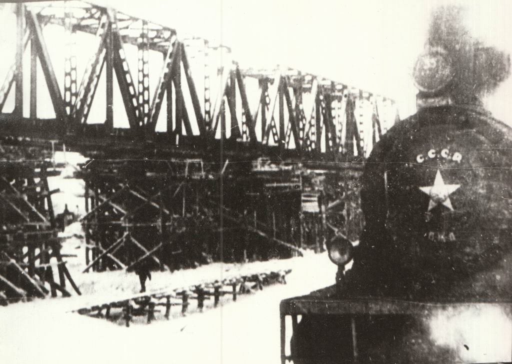 Идёт строительство Печорского железнодорожного моста.  Поезд идёт по ледовой переправе через реку Печору. Зима 1941 г.